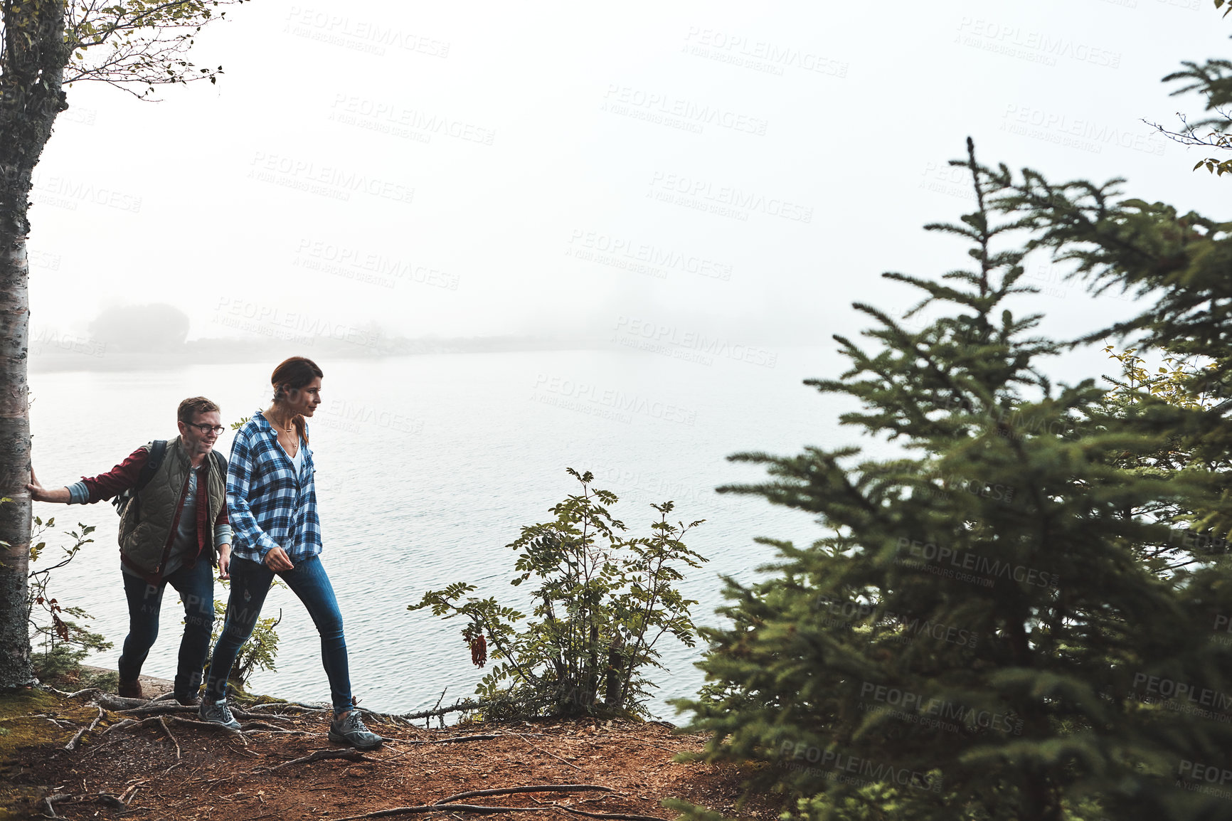 Buy stock photo Shot of a young couple exploring nature together