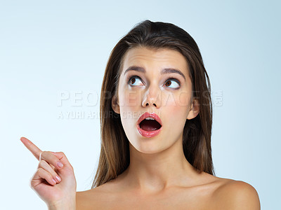 Buy stock photo Wow, pointing and beauty woman isolated on blue background for sale, discount or makeup promotion deal. Surprise face of cosmetics model or young person in studio showing mockup or product placement