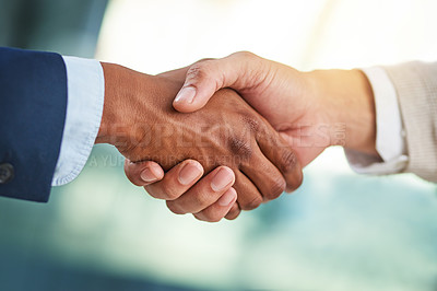 Buy stock photo Cropped shot of two businessmen shaking hands in a modern office