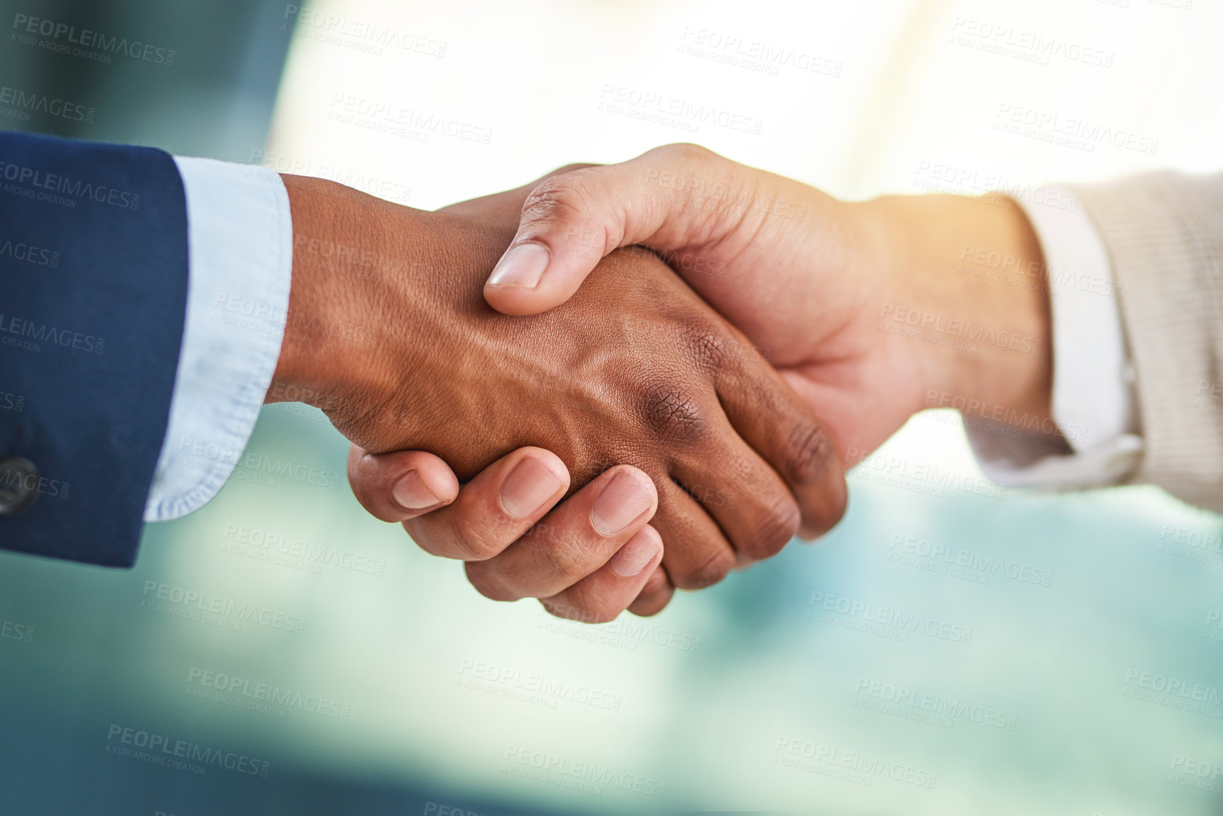 Buy stock photo Cropped shot of two businessmen shaking hands in a modern office