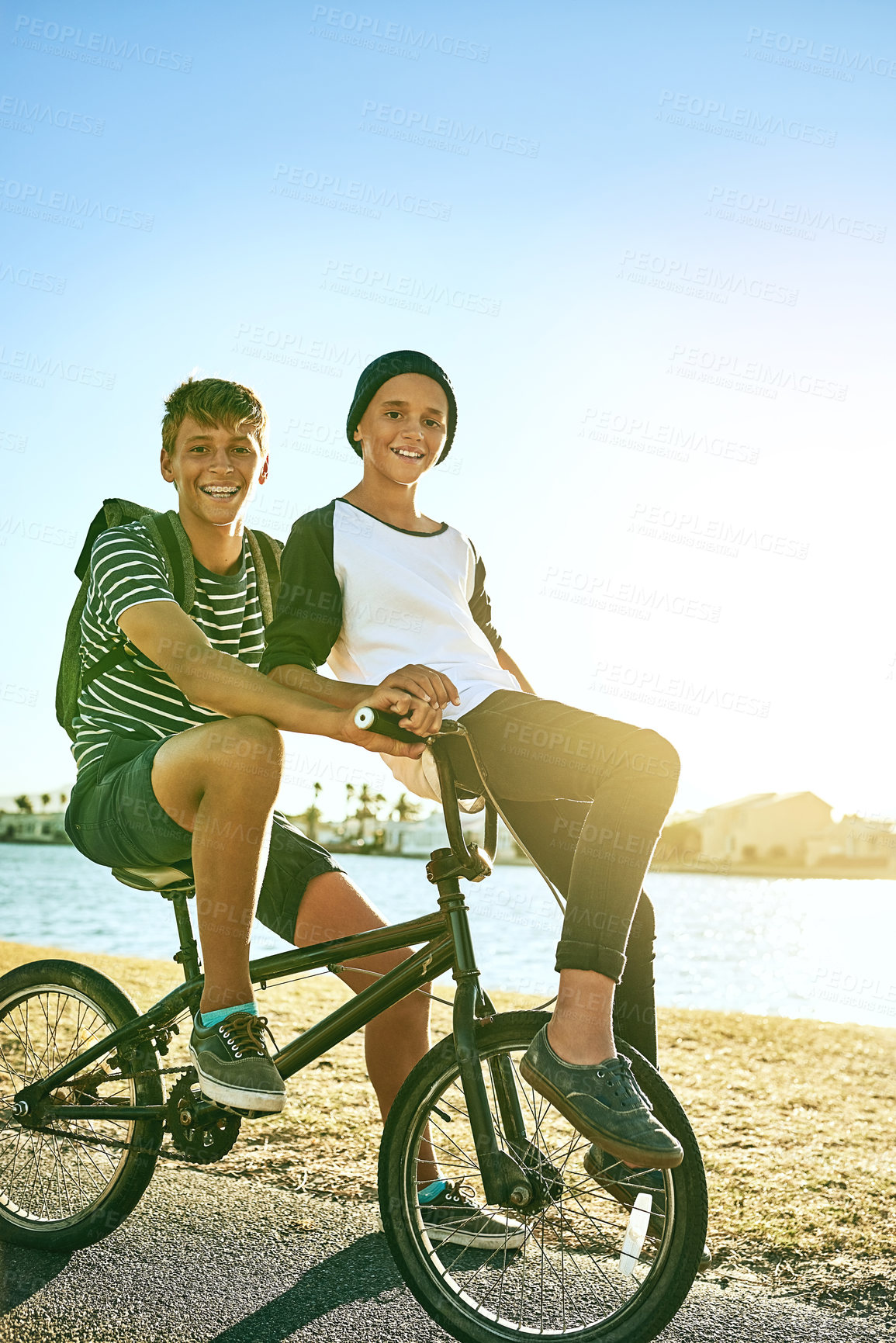 Buy stock photo Happy boys, portrait and friends with bicycle in nature for commute, travel or outdoor adventure. Male person, teenagers and students cycling back home on bike, road or street by lake, water or river