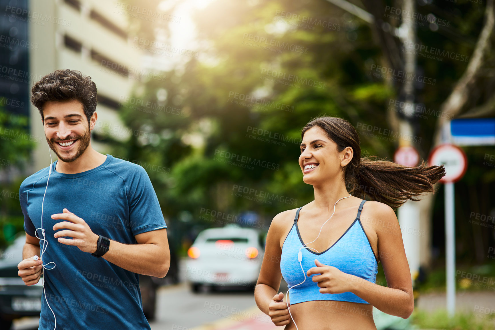 Buy stock photo Couple, earphones and run in city for fitness, cardio or club with audio or podcast. Technology, listen or training  and mobile or online personal trainer, coach or happy people for exercise outside 