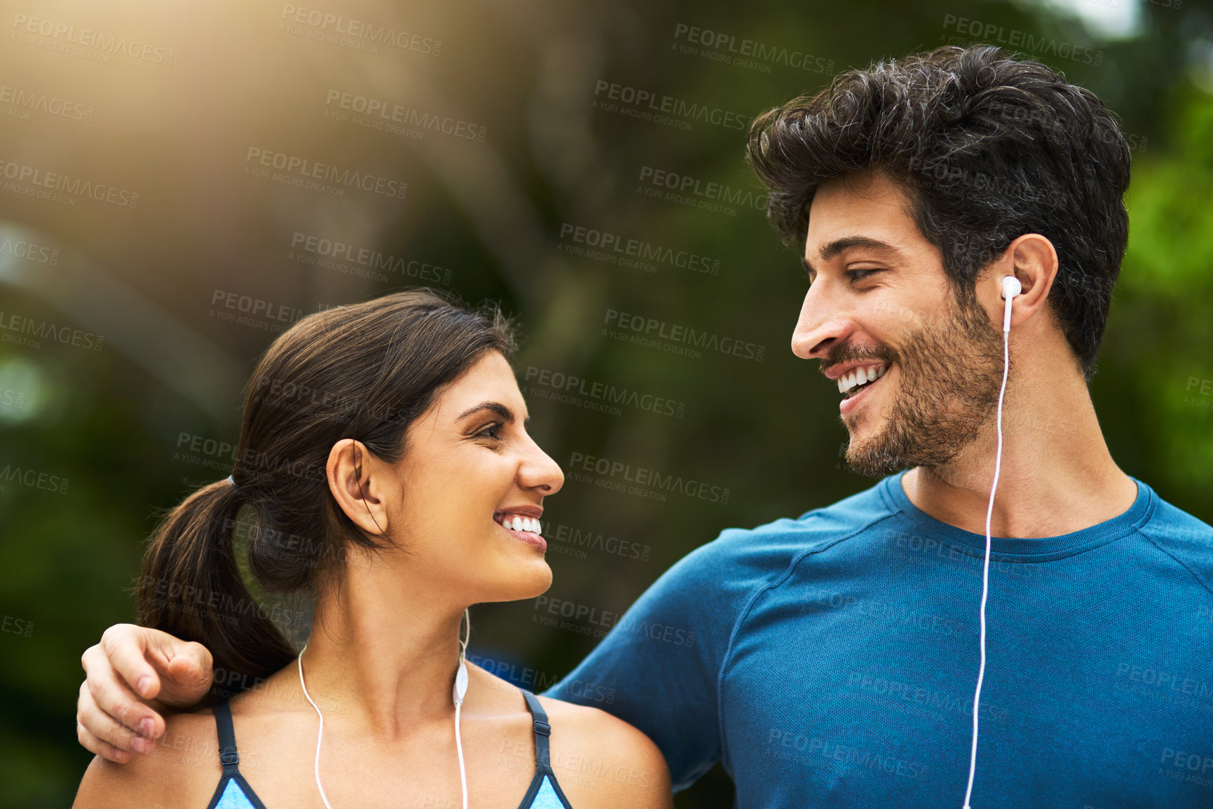 Buy stock photo Couple, love and earphones for music in nature, park and audio book for relax outdoor for walk. Fitness, exercise and cardio for Indian man and female person, smile and technology for sports workout