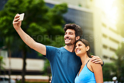 Buy stock photo Shot of a sporty young couple taking a selfie together outdoors