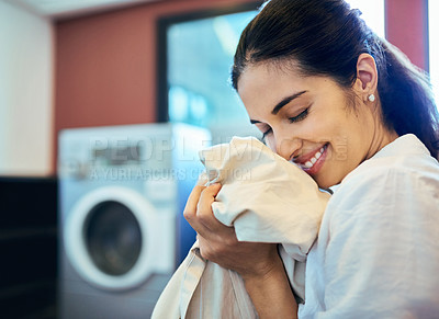 Buy stock photo Cropped shot of an attractive young woman doing laundry at home