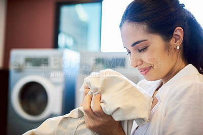 Buy stock photo Cropped shot of an attractive young woman doing laundry at home