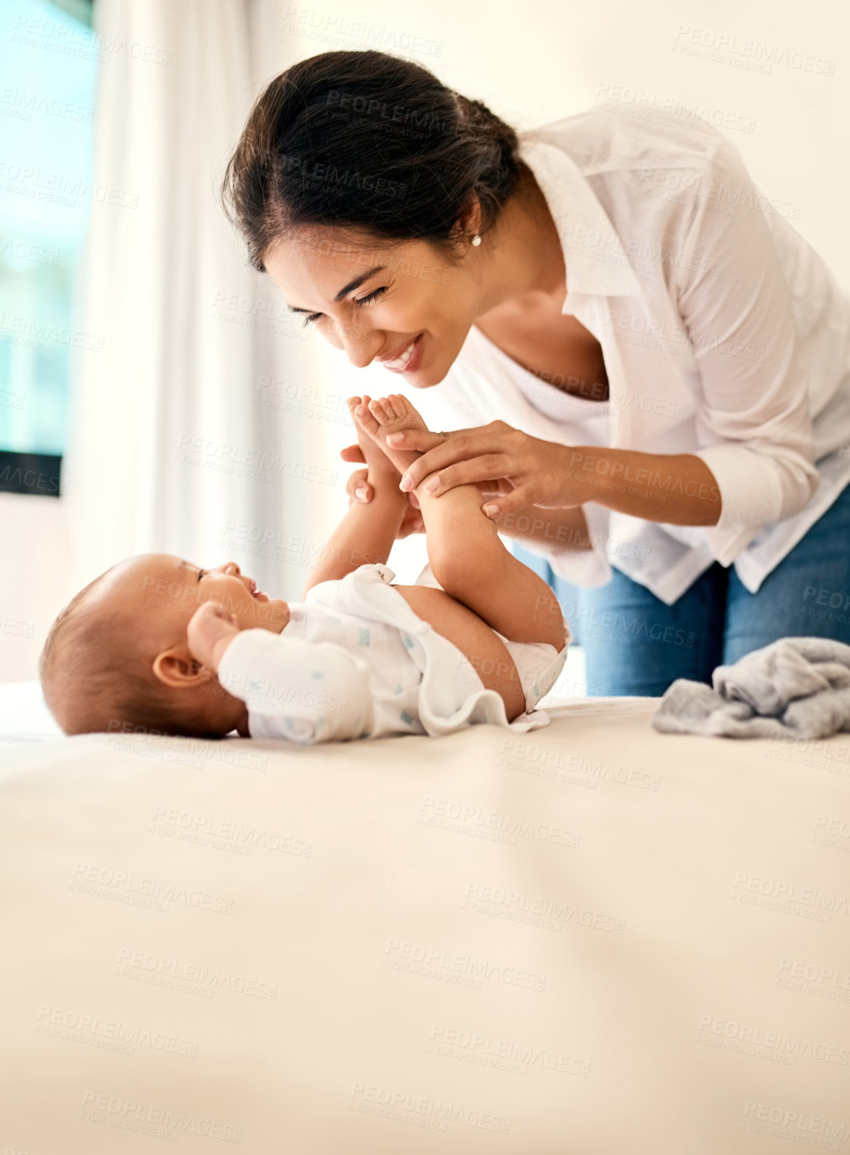 Buy stock photo Smile, love and a mother with her baby in the bedroom of their home together for playful bonding. Family, kids and a happy young mama spending time with her newborn infant on the bed for fun or joy