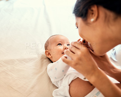 Buy stock photo Smile, love and a mother with her baby on the bed in their home together for playful bonding. Family, kids and a happy young mama spending time with her newborn infant in the bedroom for fun or joy