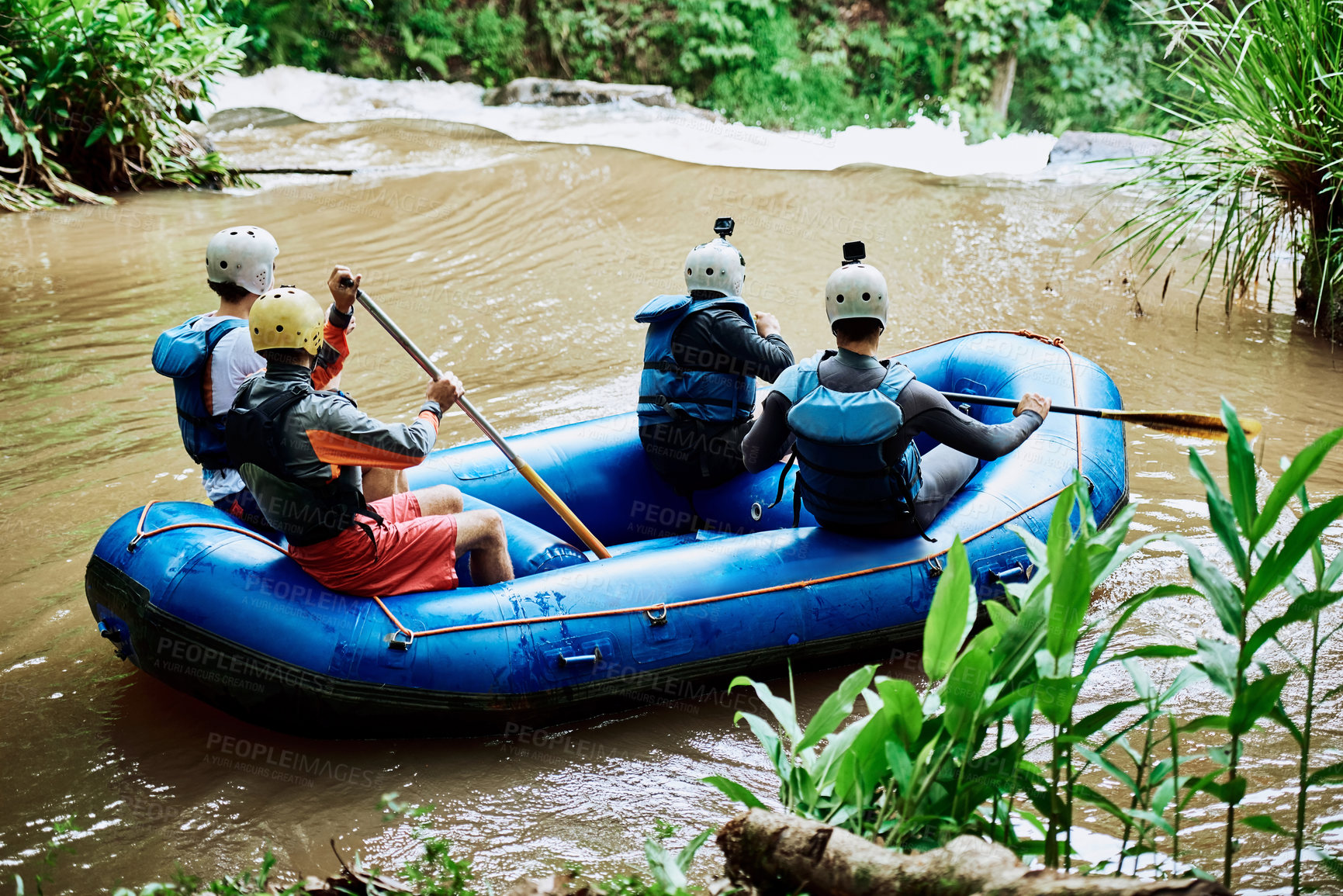 Buy stock photo Rearview shot of a group of unrecognizable people paddling down a peaceful river on a rubber boat together outside during the day