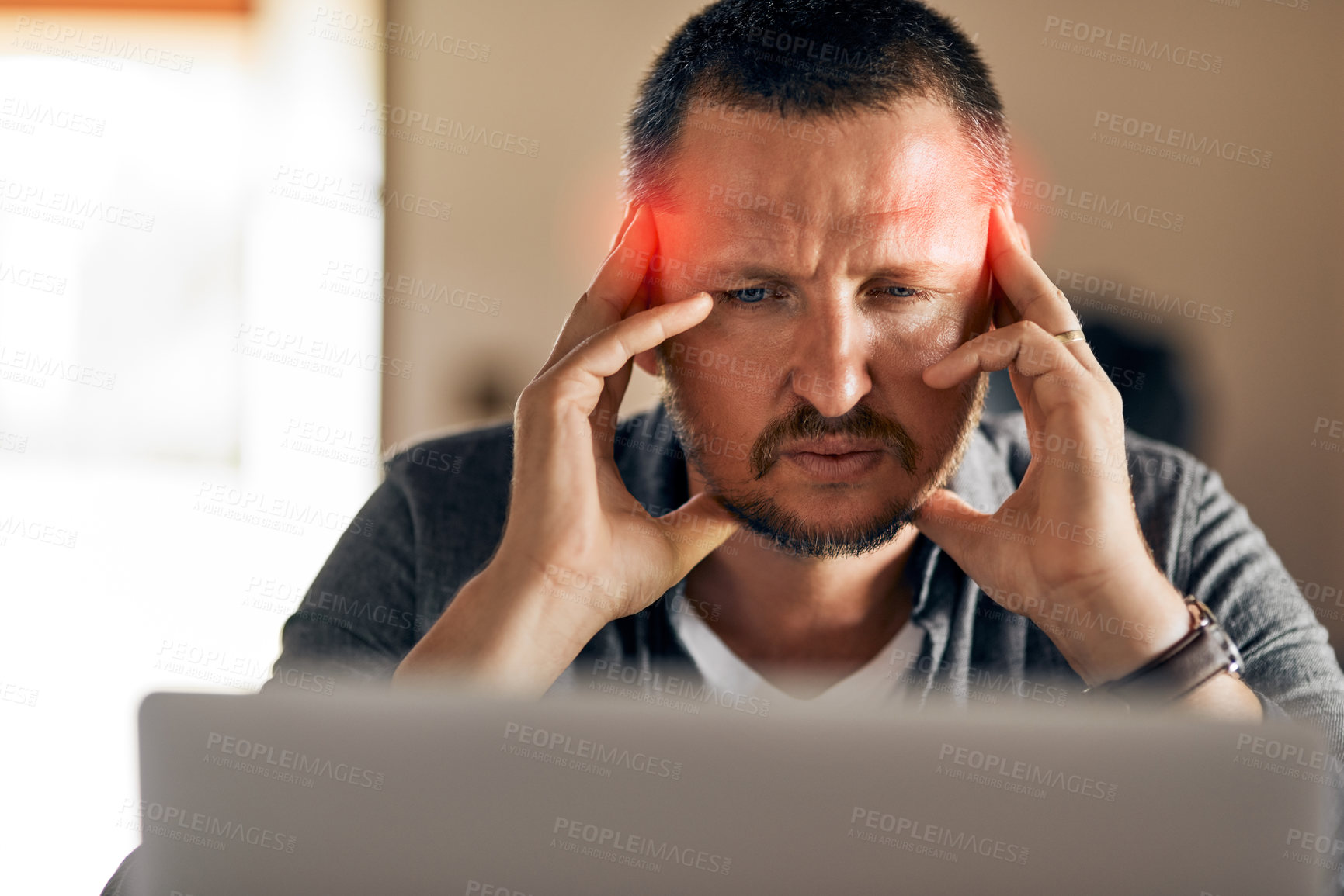 Buy stock photo Cropped shot of a man experiencing a headache at home