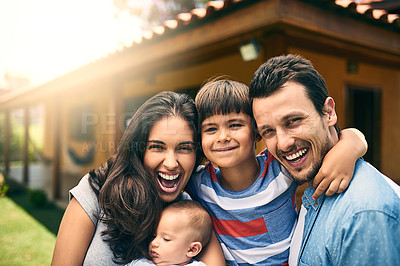 Buy stock photo Cropped portrait of a happy young family of four outside with their house in the background