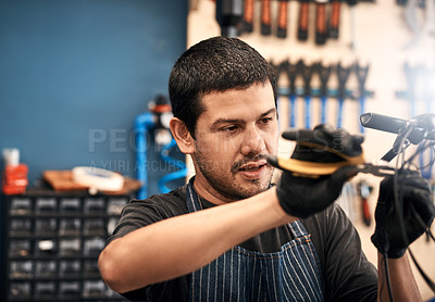 Buy stock photo Shot of a man working in a bicycle repair shop