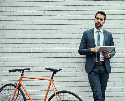 Buy stock photo Business man, street and tablet with bicycle by wall, commute and sustainable travel in city. Person, suit and bike for eco friendly transportation with touchscreen, app and mock up space in Milan