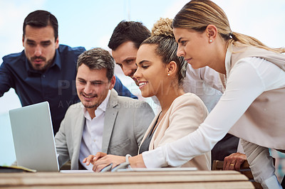 Buy stock photo Cropped shot of a group of businesspeople gathered around a laptop during a meeting in the boardroom