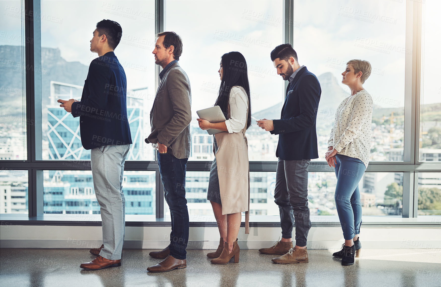 Buy stock photo Shot of a group of businesspeople standing in line in an office