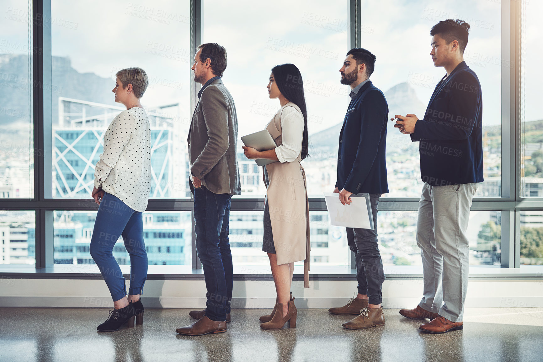 Buy stock photo Shot of a group of businesspeople standing in line in an office