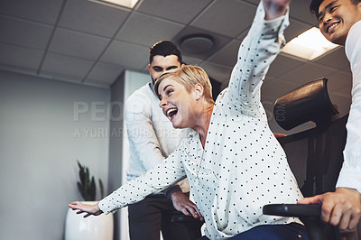 Buy stock photo Freedom, chair and colleagues in office, ride and celebration for work anniversary, playful and professional. Fun, pushing and games with friends, cheerful and happy people in creative business