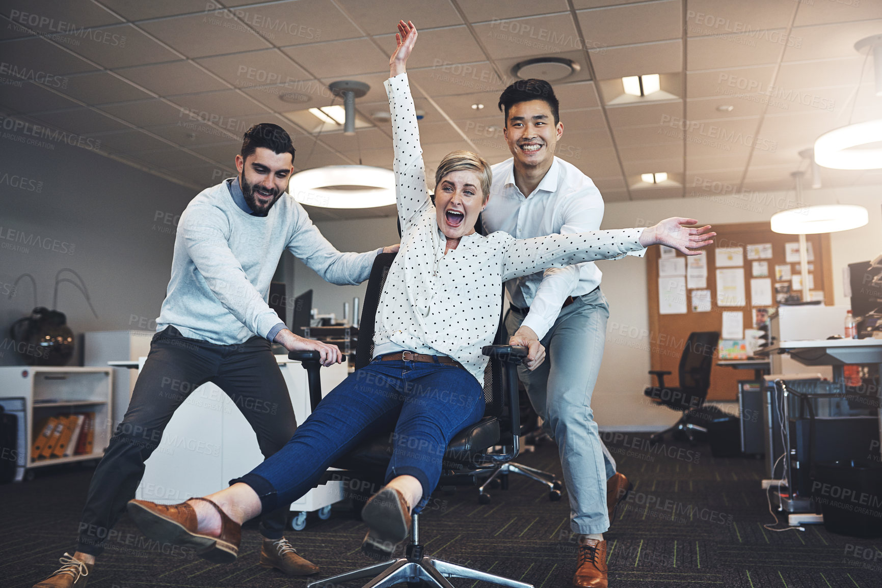 Buy stock photo Crazy, chair and colleagues in office, ride and celebration for work anniversary, playful or professional. Fun, pushing and games with friends, cheerful and happy people in creative business or silly