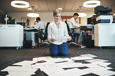 Buy stock photo Shot of a businesswoman working with paperwork on the floor in the office