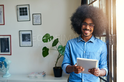 Buy stock photo Cropped portrait of a handsome young male designer working on a tablet in his office