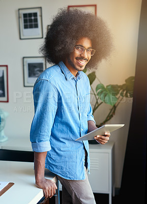 Buy stock photo Cropped portrait of a handsome young male designer working on a tablet in his office
