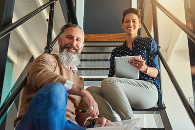 Buy stock photo Shot of creative colleagues on steps in a modern office