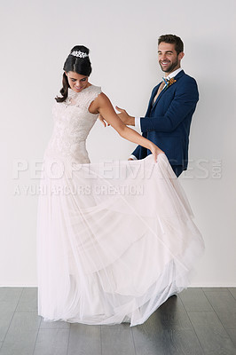 Buy stock photo Studio shot of a newly married young couple standing against a gray background