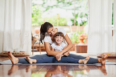 Buy stock photo Portrait of a cheerful young mother and daughter doing a yoga pose together while holding each other in a spit position