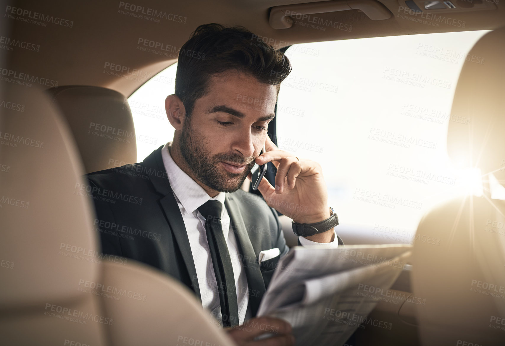 Buy stock photo Businessman, newspaper and reading in car with phone call for career, meeting or conversation. Male person, transport and commute on mobile tech as professional or investment banker for luxury travel