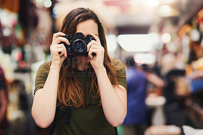 Buy stock photo Portrait of an unrecognizable young woman taking a photo at the screen while standing at a market outside during the day
