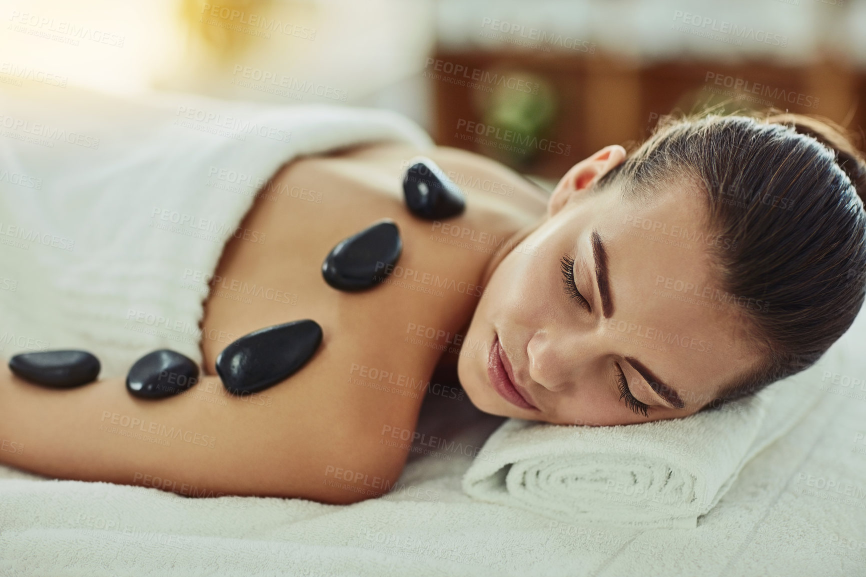 Buy stock photo Shot of an attractive young woman getting a hot stone massage at a beauty spa