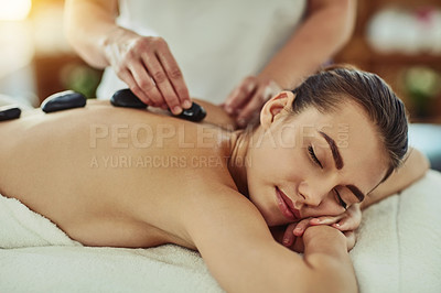 Buy stock photo Spa, zen and woman getting a hot stone back massage for luxury, calm and natural self care. Beauty, body care and tranquil female person sleeping while doing a rock body therapy treatment at a salon.