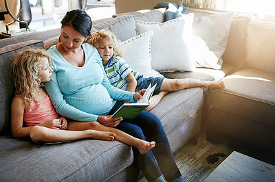 Buy stock photo Shot of a pregnant woman spending time with her children at home