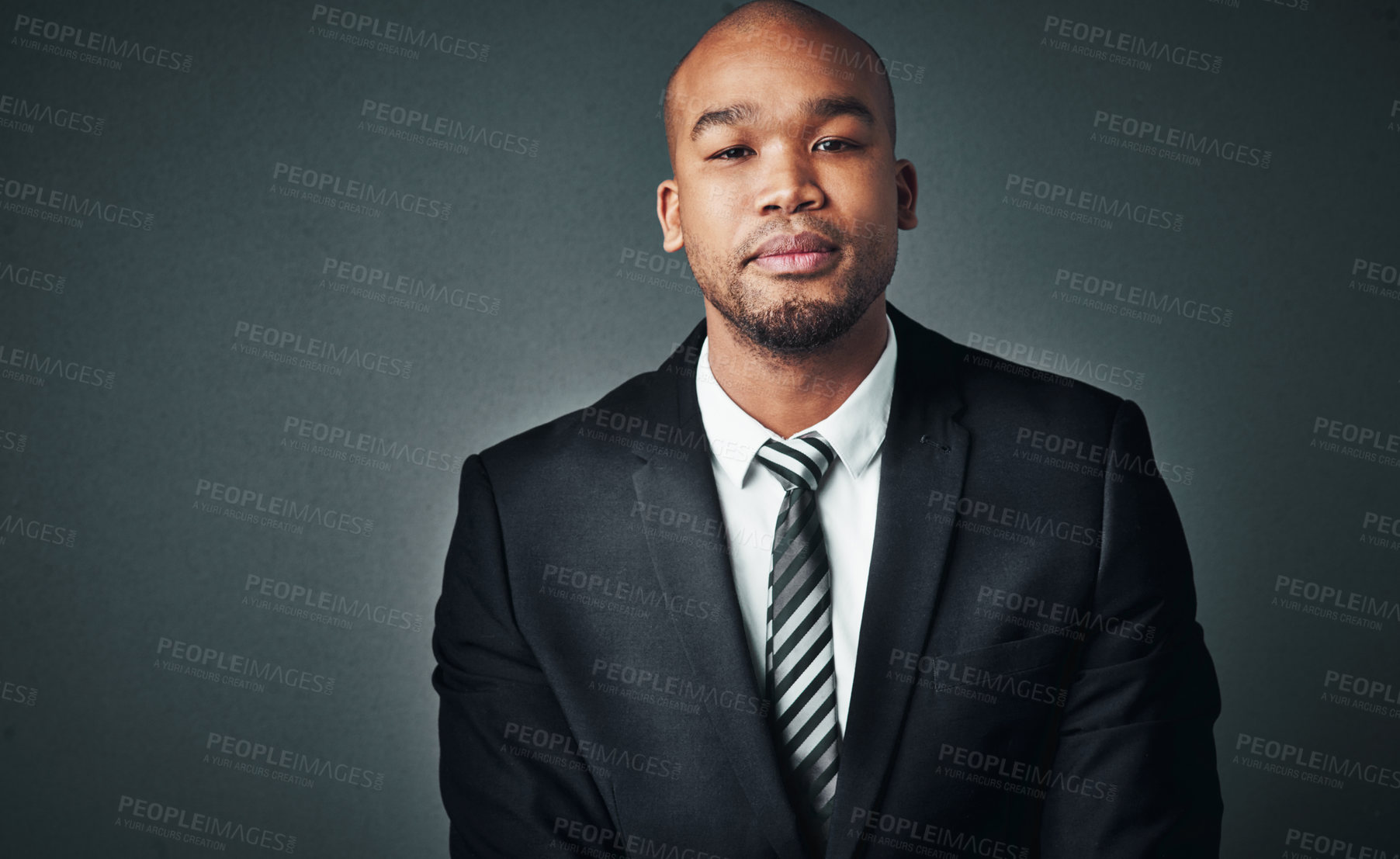 Buy stock photo Studio shot of a handsome young businessman posing against a gray background