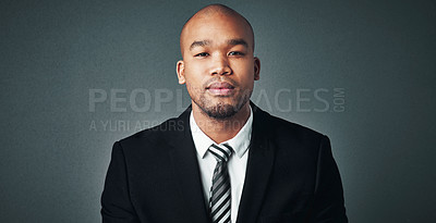 Buy stock photo Studio shot of a handsome young businessman posing against a gray background