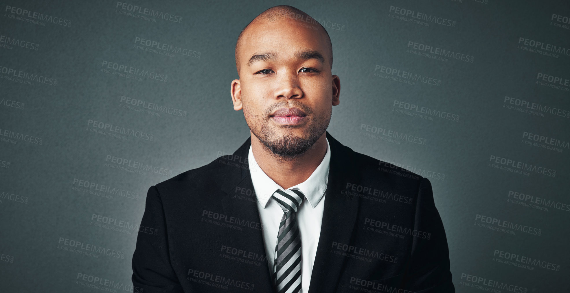 Buy stock photo Studio shot of a handsome young businessman posing against a gray background