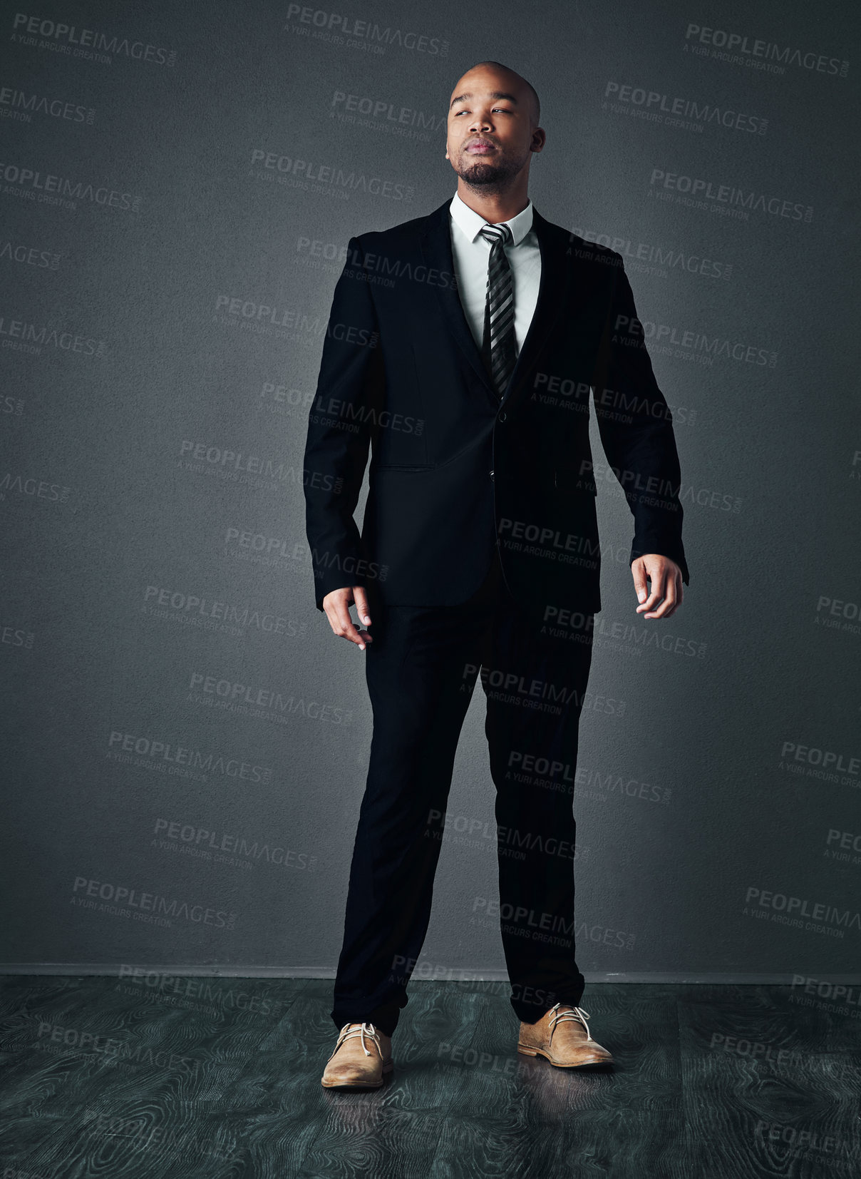 Buy stock photo Studio shot of a handsome young businessman posing against a gray background