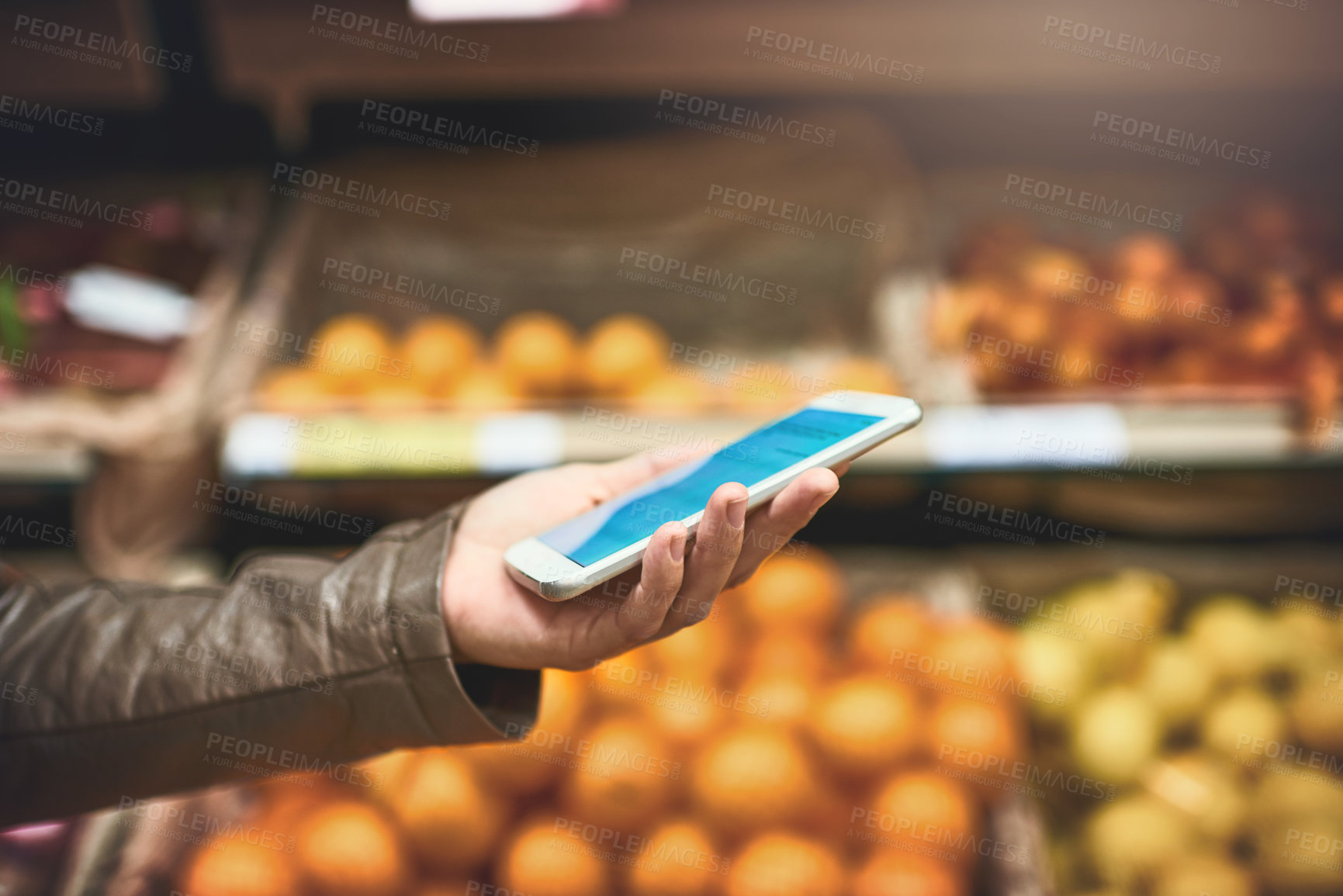 Buy stock photo Cropped shot of a woman using a mobile phone in a grocery store