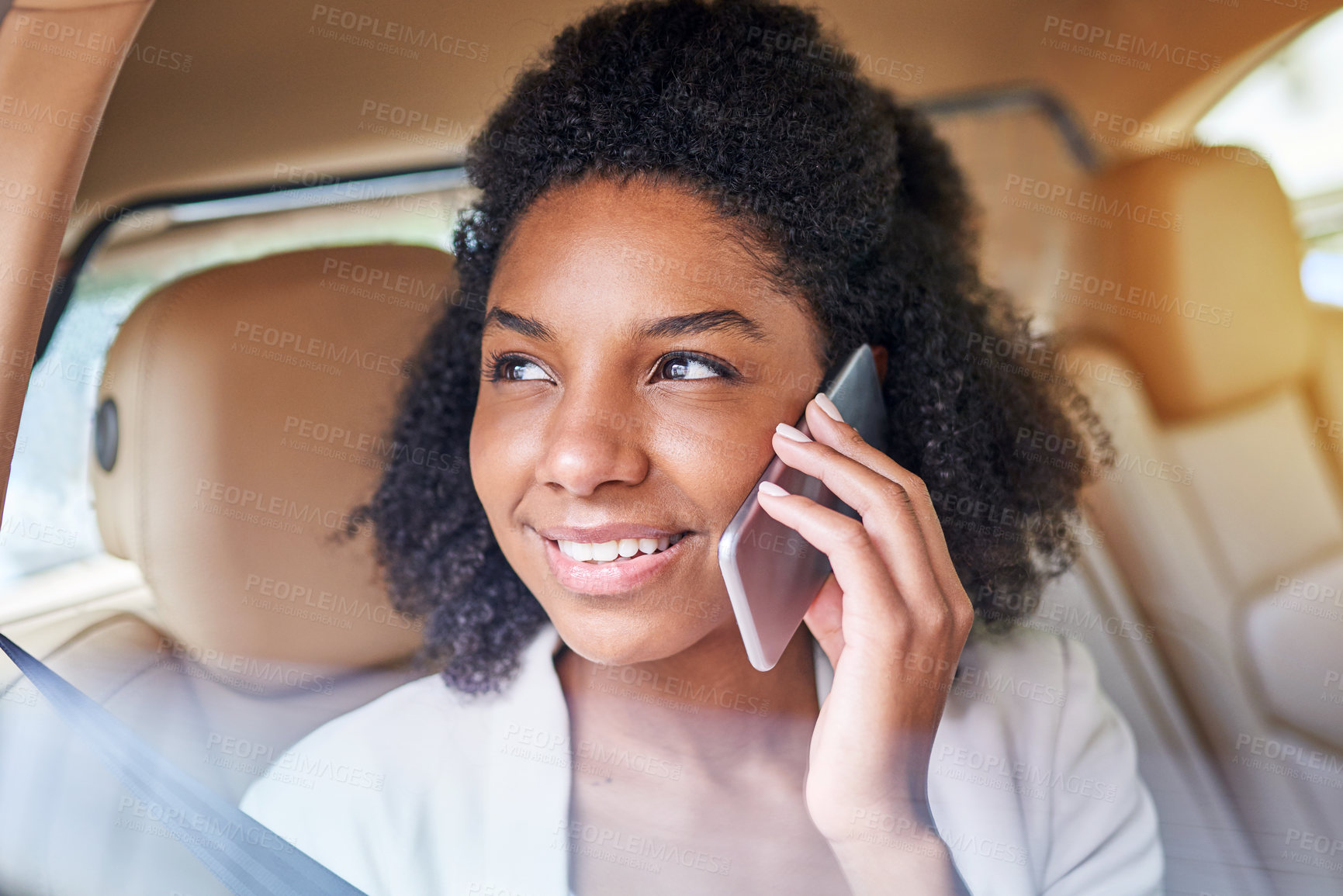 Buy stock photo Shot of an attractive young businesswoman making a phonecall while being driven to work on her morning commute