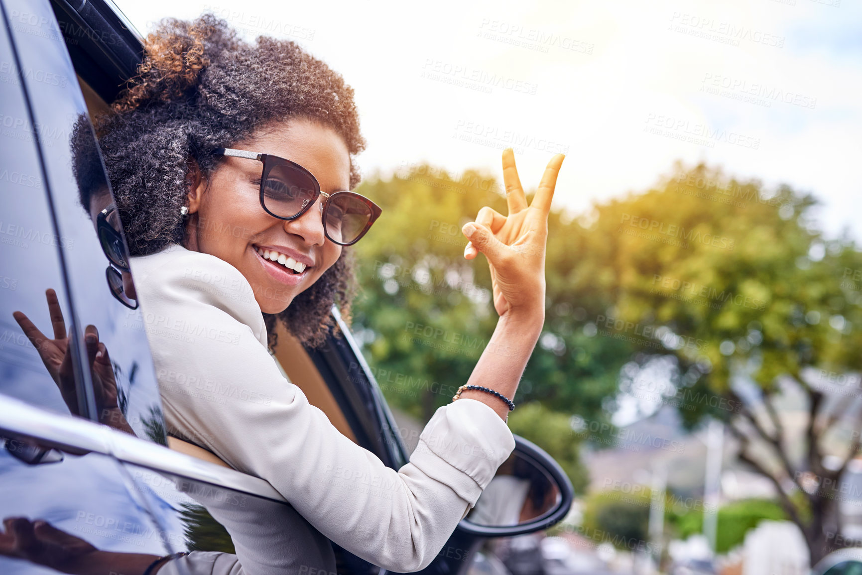 Buy stock photo Portrait of an attractive young businesswoman giving you the peace sign while driving to work on her morning commute