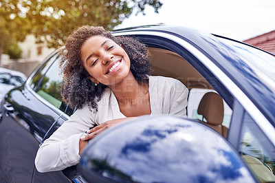 Buy stock photo Shot of an attractive young businesswoman leaning out of her window while driving to work on her morning commute