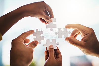 Buy stock photo Cropped shot of businesspeople completing a puzzle together in a modern office