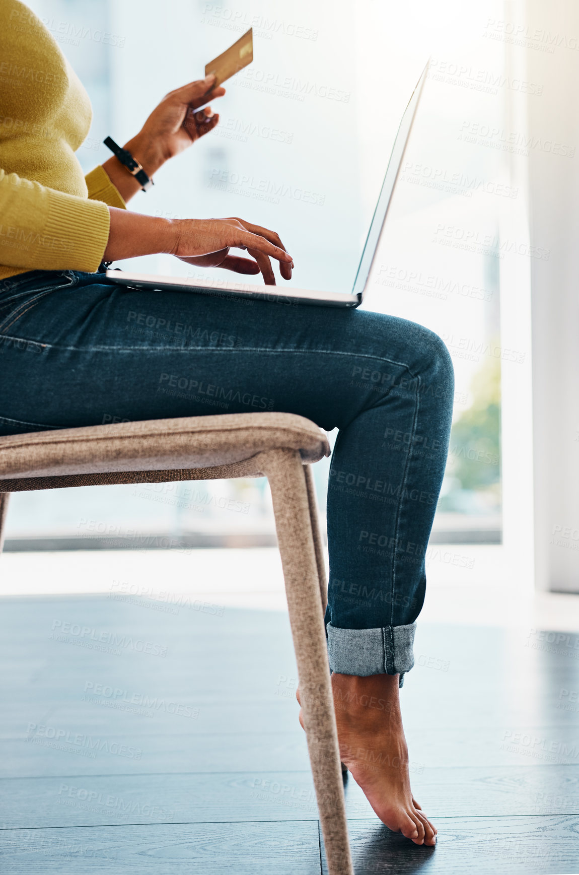 Buy stock photo Cropped shot of a woman using her credit card to make an online payment at home