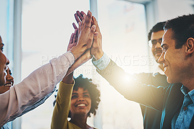 Buy stock photo Shot of a group of businesspeople high fiving in an office