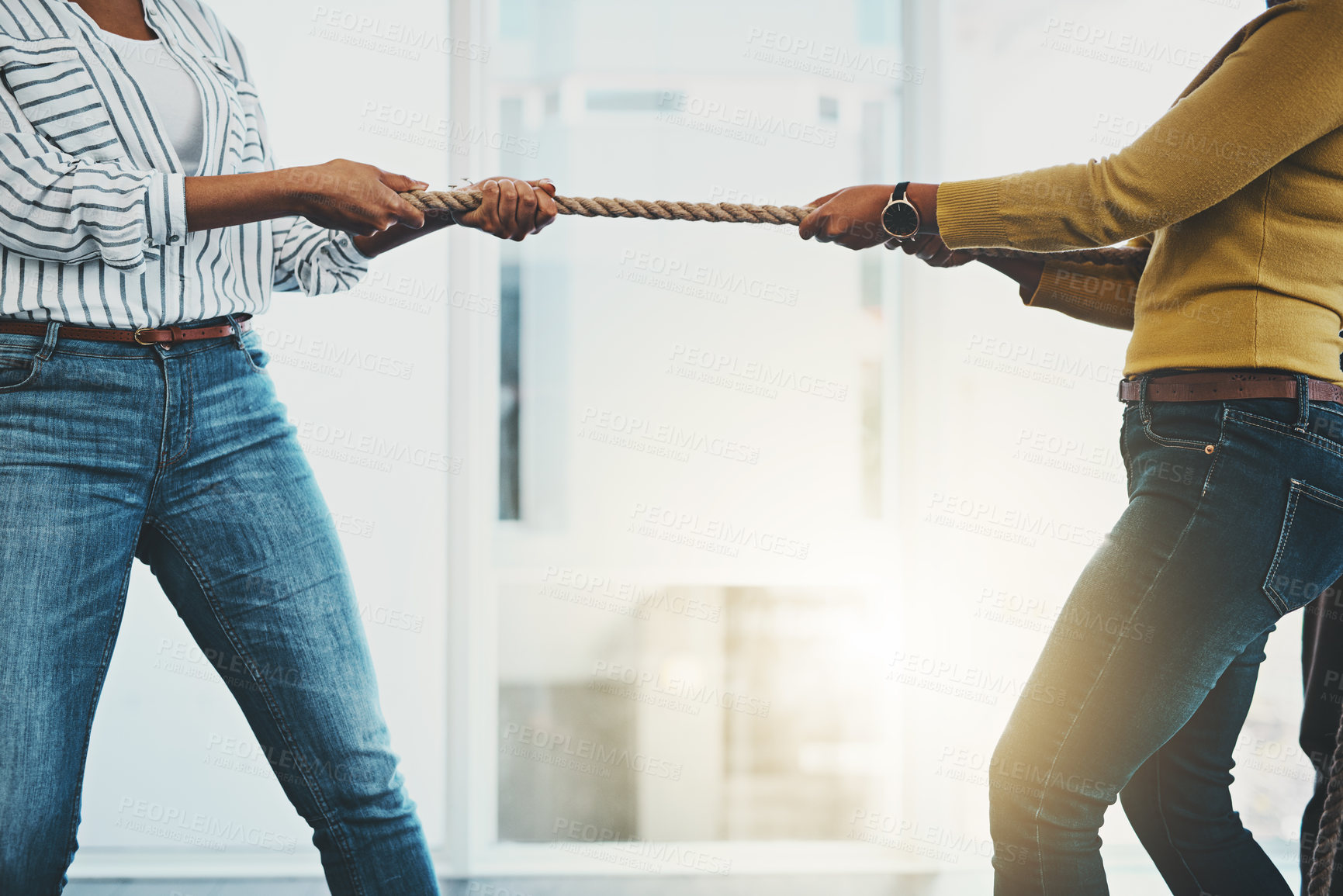 Buy stock photo Closeup shot of two unrecognizable women pulling on a rope during tug of war
