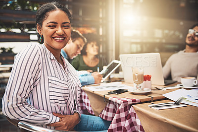 Buy stock photo Portrait of a cheerful young woman seated with her friends next to a table at a coffeeshop outside during the day