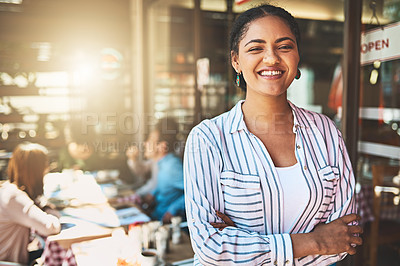 Buy stock photo Portrait of a confident young woman standing with her arms folded inside of a coffeeshop during the day