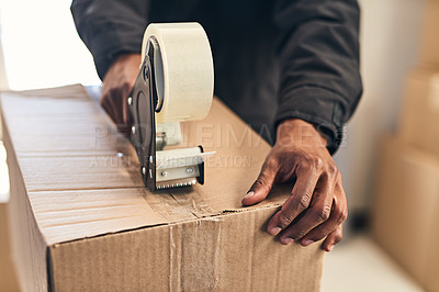 Buy stock photo Closeup shot of an unrecognizable courier sealing a box with tape for delivery