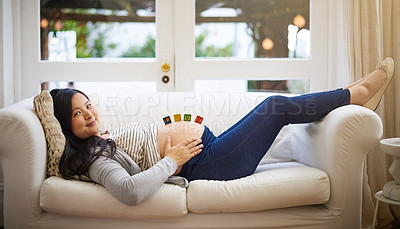 Buy stock photo Cropped portrait of an attractive young pregnant woman relaxing on the sofa at home