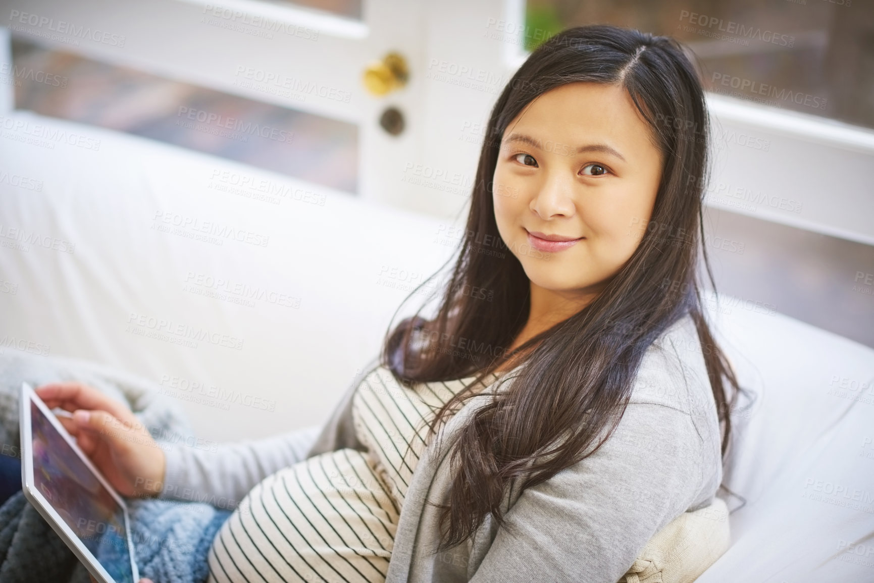 Buy stock photo Portrait of a pregnant woman using a digital tablet at home